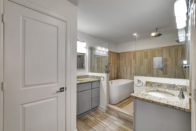 bathroom featuring vanity and independent shower and bath