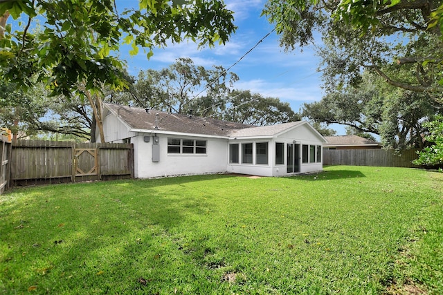 back of house featuring a yard and a sunroom