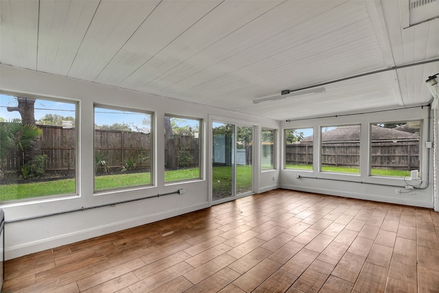 unfurnished sunroom featuring wooden ceiling and a water view