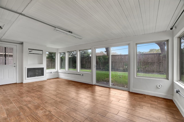 unfurnished sunroom with an AC wall unit