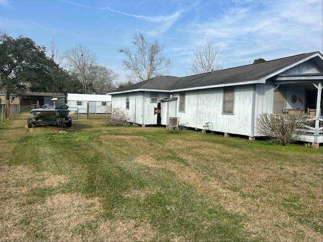 view of front of home with central AC unit and a front lawn