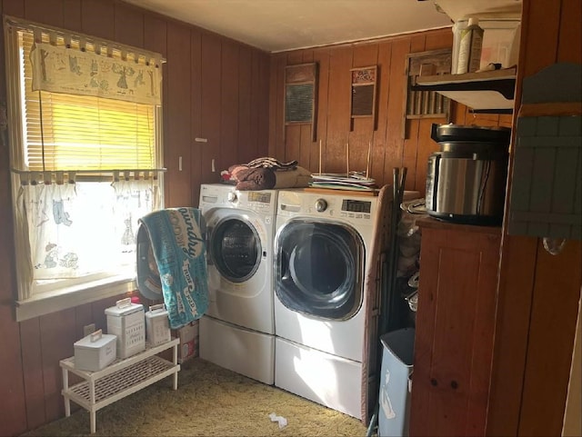 laundry area with carpet, washer and dryer, and wood walls