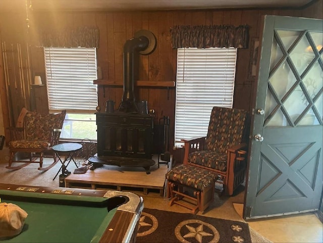 sitting room featuring a wood stove and wooden walls