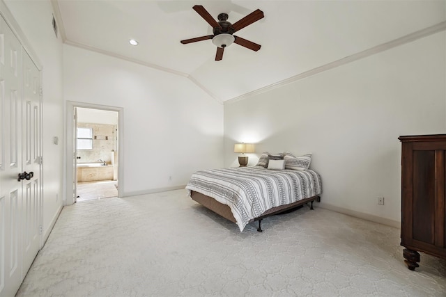 carpeted bedroom featuring ensuite bath, vaulted ceiling, ornamental molding, and ceiling fan