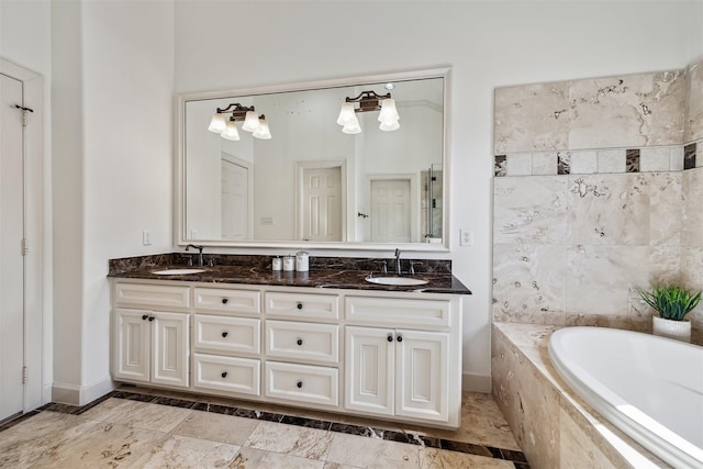 bathroom featuring vanity and tiled tub