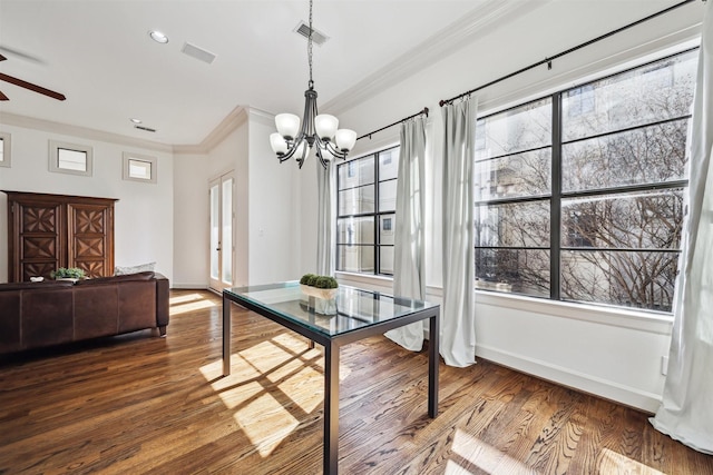 dining space with crown molding, wood-type flooring, and ceiling fan with notable chandelier