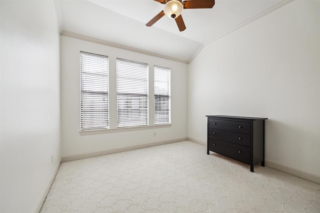 empty room featuring ornamental molding, lofted ceiling, light colored carpet, and ceiling fan