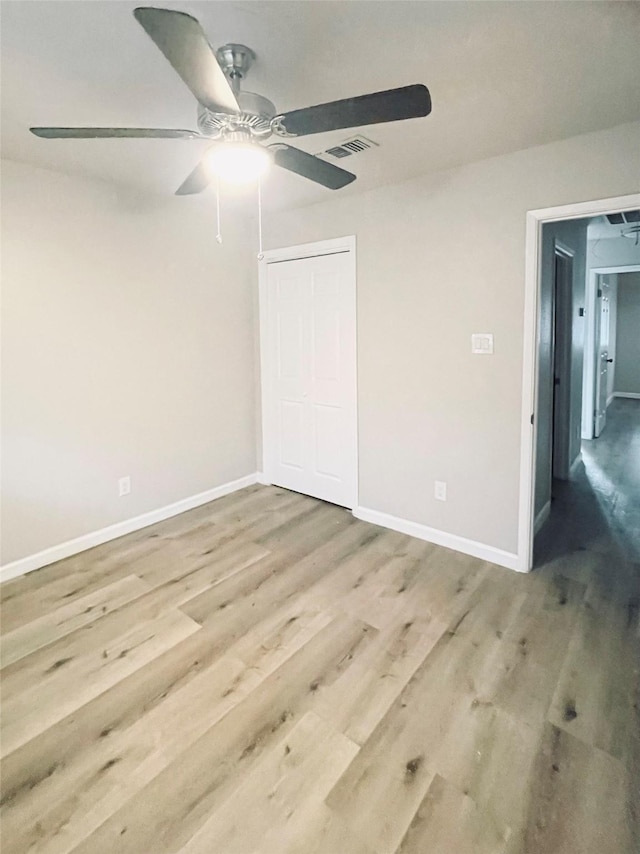 unfurnished bedroom featuring light hardwood / wood-style flooring, a closet, and ceiling fan