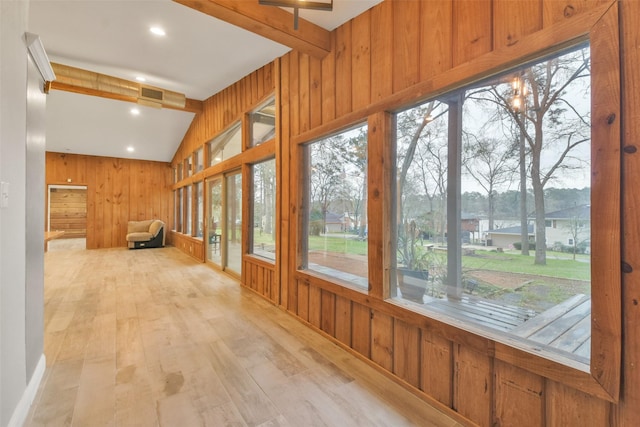 unfurnished sunroom featuring a healthy amount of sunlight and lofted ceiling with beams