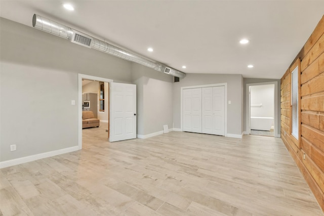 interior space featuring light wood-type flooring and lofted ceiling