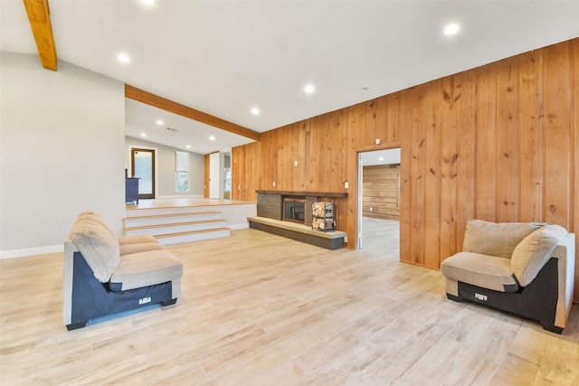 living room with light hardwood / wood-style floors, vaulted ceiling with beams, and wooden walls