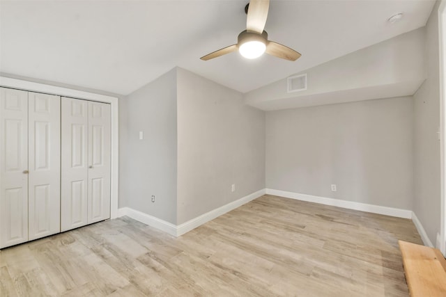 unfurnished bedroom featuring a closet, vaulted ceiling, ceiling fan, and light hardwood / wood-style flooring