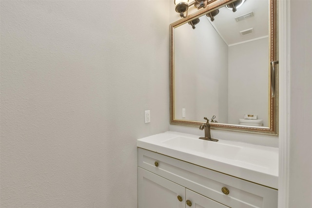 bathroom featuring ornamental molding, toilet, and vanity