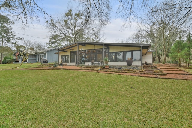 back of property with a yard and a sunroom