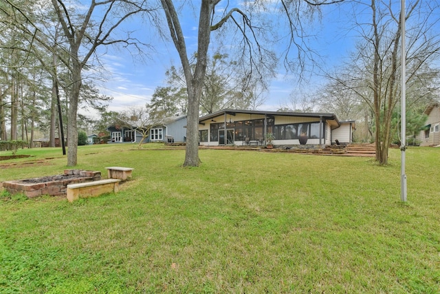 rear view of house with a yard and a sunroom