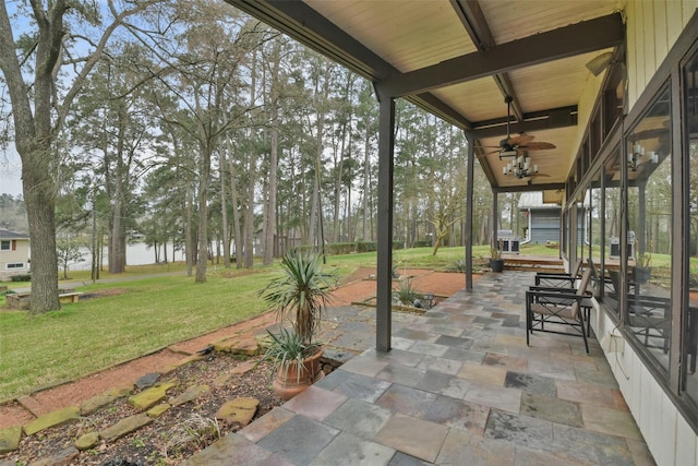 view of patio with a water view and ceiling fan