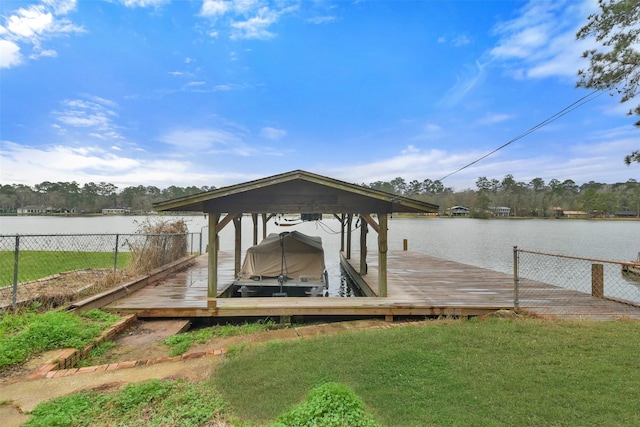 view of dock with a lawn and a water view