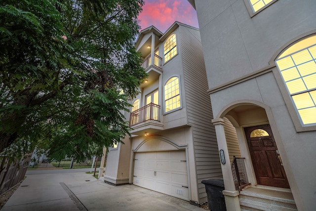 exterior entry at dusk featuring a garage