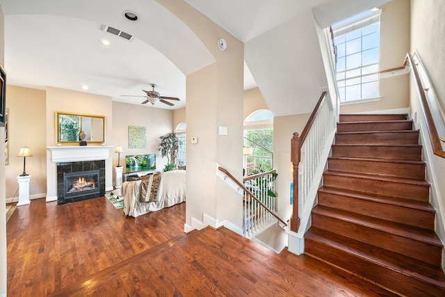 interior space with ceiling fan, wood-type flooring, and a tile fireplace