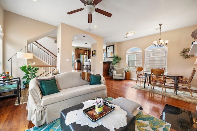 living room with dark hardwood / wood-style floors and ceiling fan with notable chandelier