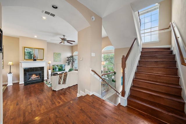 interior space featuring a fireplace, wood-type flooring, and ceiling fan