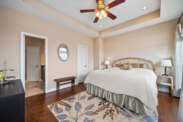 bedroom with dark hardwood / wood-style floors, a raised ceiling, and ceiling fan