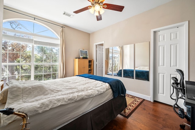 bedroom with dark hardwood / wood-style floors and ceiling fan