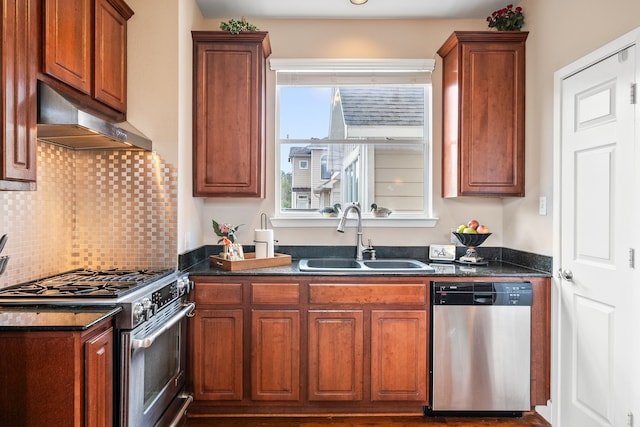 kitchen featuring tasteful backsplash, appliances with stainless steel finishes, sink, and dark stone countertops