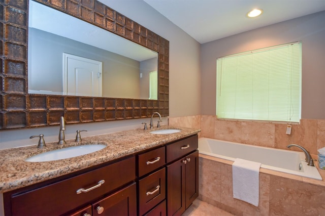 bathroom featuring a relaxing tiled tub and vanity