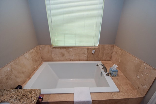 bathroom featuring vanity and tiled tub