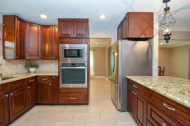 kitchen featuring pendant lighting, crown molding, appliances with stainless steel finishes, tasteful backsplash, and light stone countertops