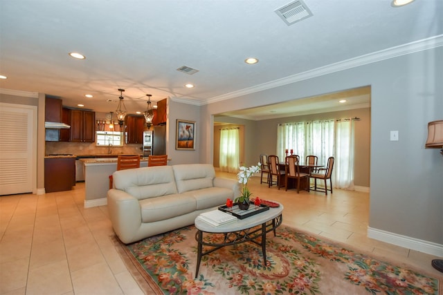 living room featuring crown molding, plenty of natural light, sink, and light tile patterned floors