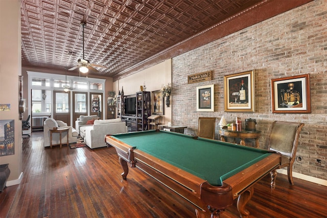 recreation room with hardwood / wood-style floors, baseboards, brick wall, an ornate ceiling, and ceiling fan