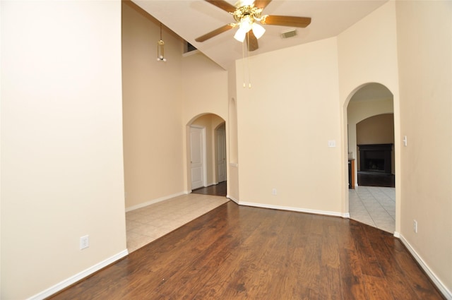 9210 Hidden Lake E Lake E, Magnolia, TX 77354 - empty room featuring a ceiling fan, visible vents, high vaulted ceiling, wood finished floors, and arched walkways
