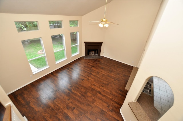 9210 Hidden Lake E Lake E, Magnolia, TX 77354 - unfurnished living room featuring lofted ceiling, a fireplace with raised hearth, baseboards, ceiling fan, and wood finished floors