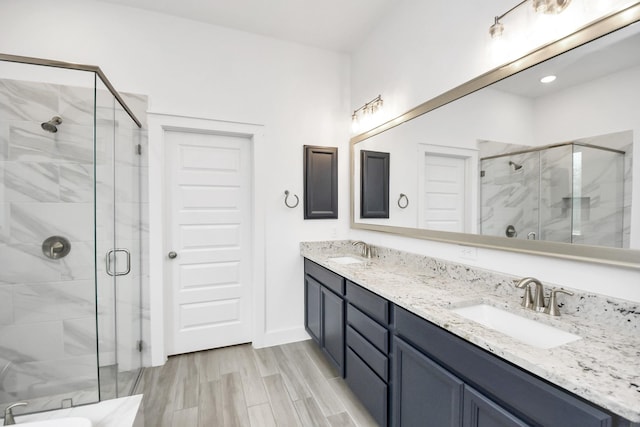 bathroom featuring a shower with door, vanity, and hardwood / wood-style flooring