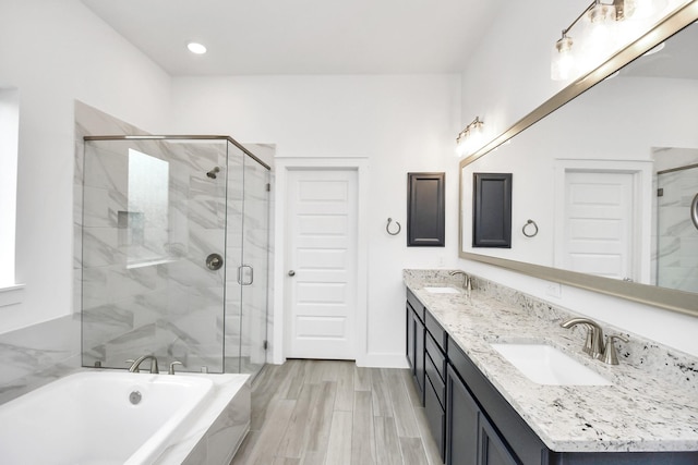 bathroom featuring wood-type flooring, separate shower and tub, and vanity