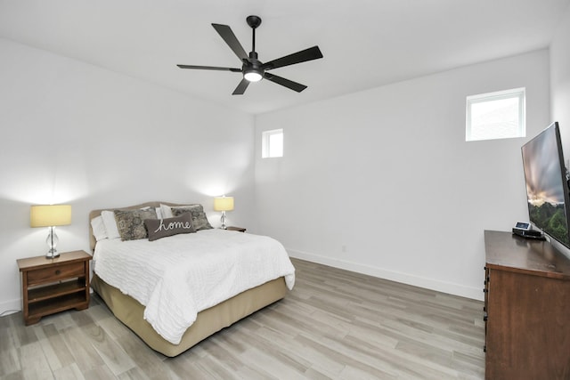 bedroom with multiple windows, ceiling fan, and light wood-type flooring