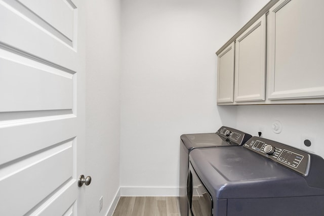 laundry area with cabinets, wood-type flooring, and independent washer and dryer