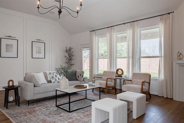 living room with hardwood / wood-style flooring, lofted ceiling, and a chandelier