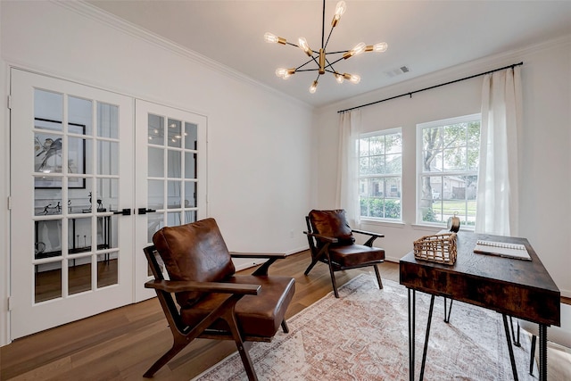 living area with ornamental molding, wood-type flooring, a notable chandelier, and french doors