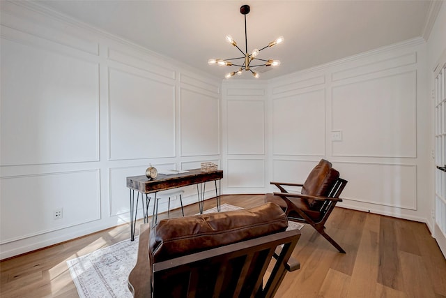 sitting room with an inviting chandelier, crown molding, and light hardwood / wood-style flooring