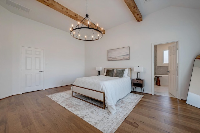 bedroom with high vaulted ceiling, beamed ceiling, a notable chandelier, light hardwood / wood-style floors, and ensuite bath