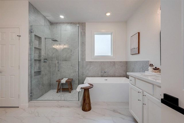 bathroom featuring shower with separate bathtub and vanity