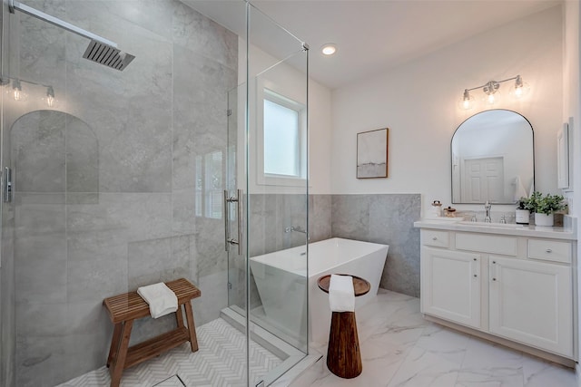 bathroom featuring vanity, independent shower and bath, and tile walls