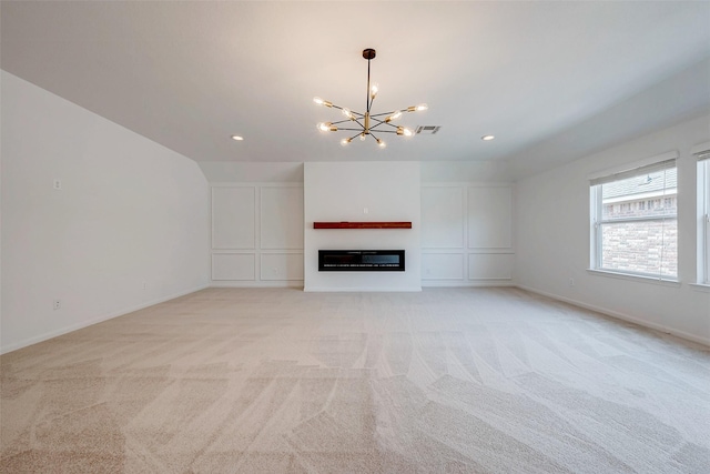 unfurnished living room featuring light colored carpet and a chandelier