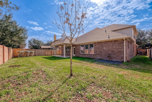 back of property with a yard, central AC unit, and a patio area