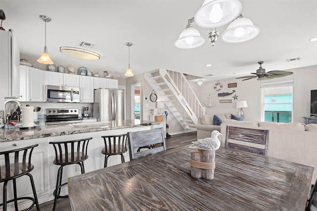 dining area with ceiling fan and dark hardwood / wood-style flooring