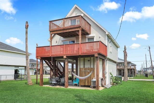 rear view of house with a wooden deck, a yard, and a patio area