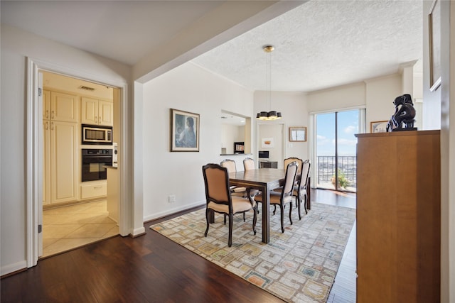 dining room with hardwood / wood-style flooring and a textured ceiling